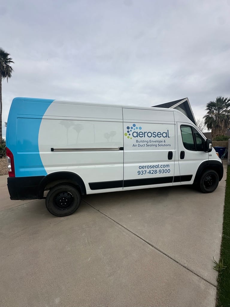 White delivery van with a blue curved graphic and the AeroSeal logo, parked on a driveway; side text includes 'AeroSeal', 'AeroSeal.com', and the phone number 937-428-9300 with the tagline 'Building Envelope & Air Duct Sealing Solutions'.